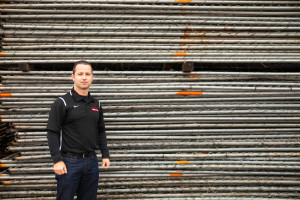 Louie Adamo in front of stacks of chain link panel fence