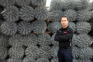 Louie Adamo in front of Post-Driven Chain Link Fence