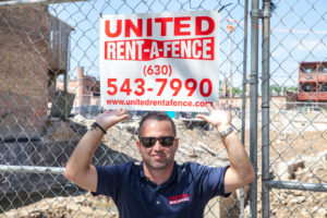 Louie posing with United Rent-A-Fence sign